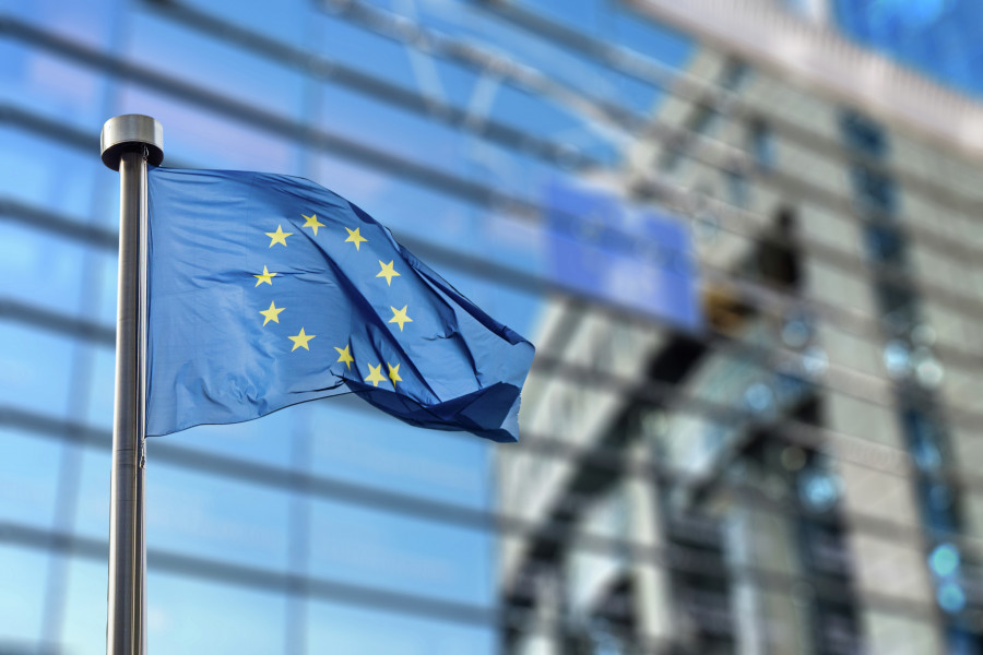Fahne der EU vor Fensterwand
