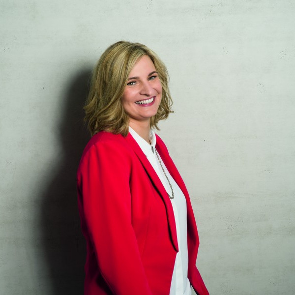 Kandidatinnenbild Cirsten Kunz (im roten Blazer vor grauem Hintergrund)